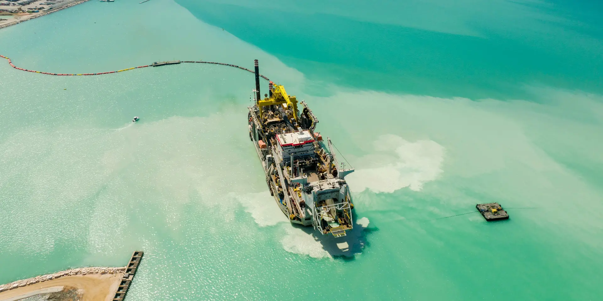 Aerial view of a cutter-suction dredger working a coastal reclamation and marine infrastructure scheme.